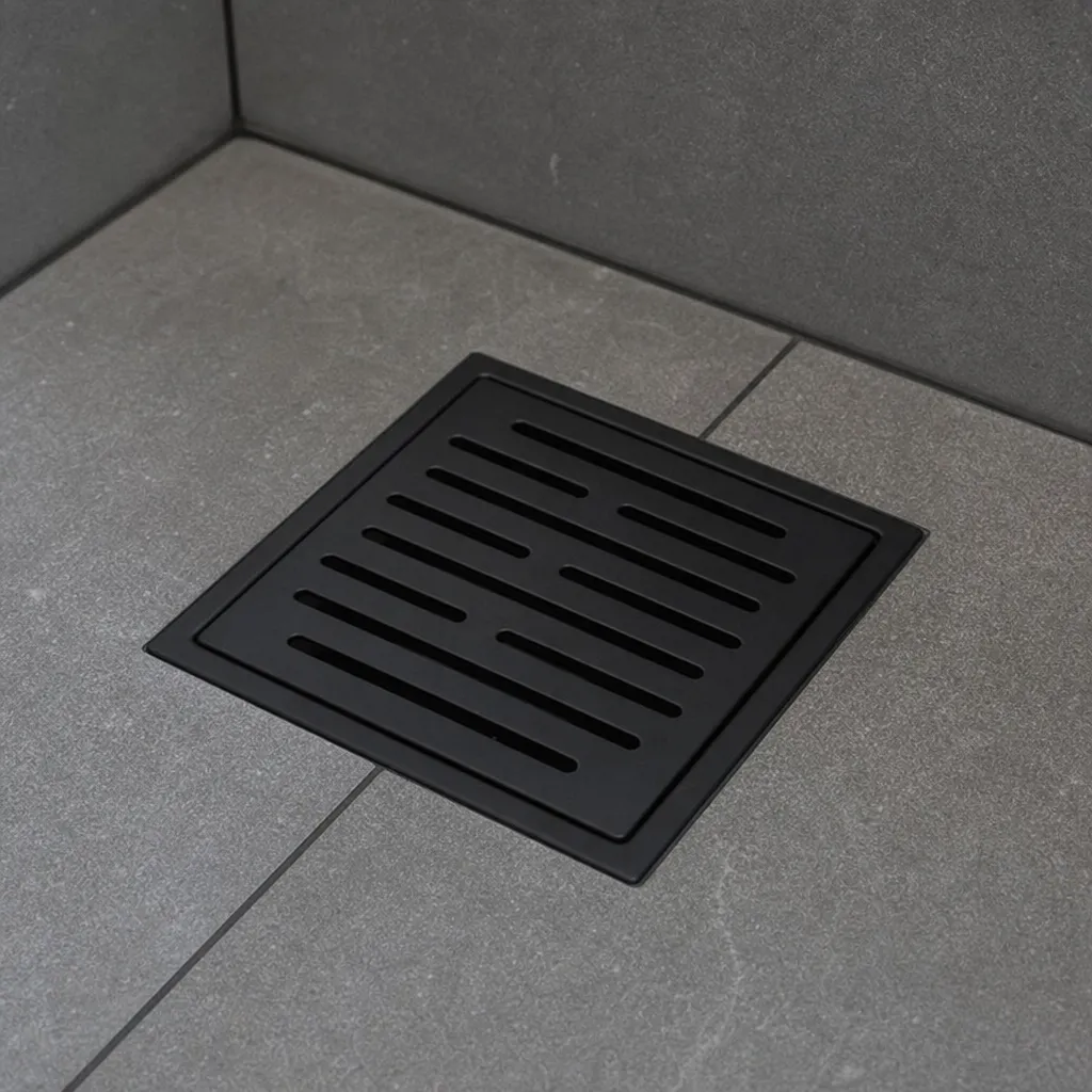 Primer plano de una elegante tapa decorativa para desagüe en negro mate en una ducha con azulejos